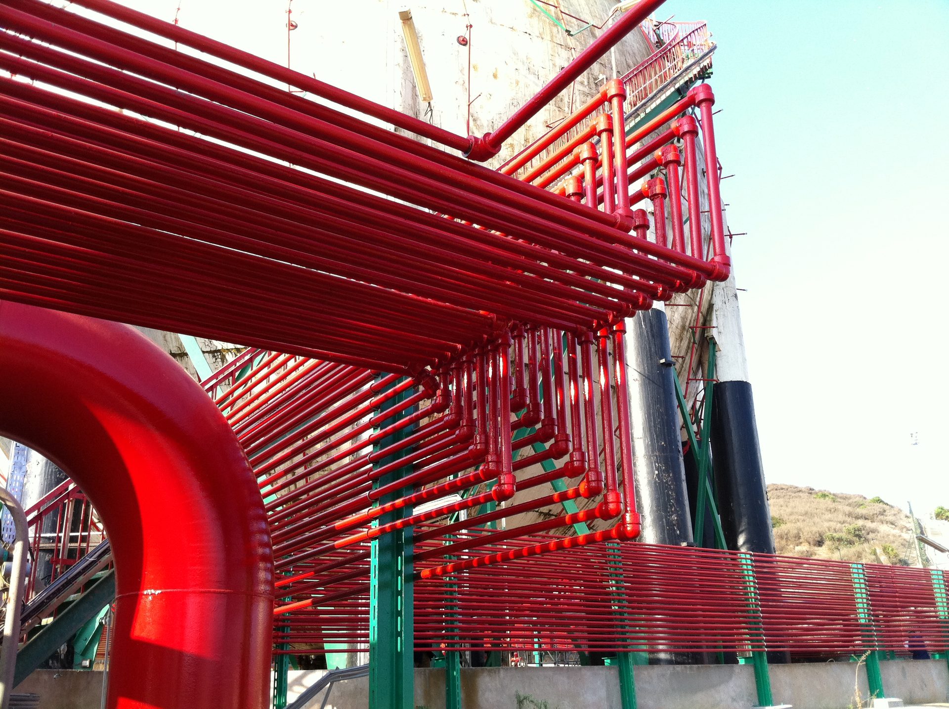 Red de tuberías rojas de protección contra incendios junto a una estructura industrial
